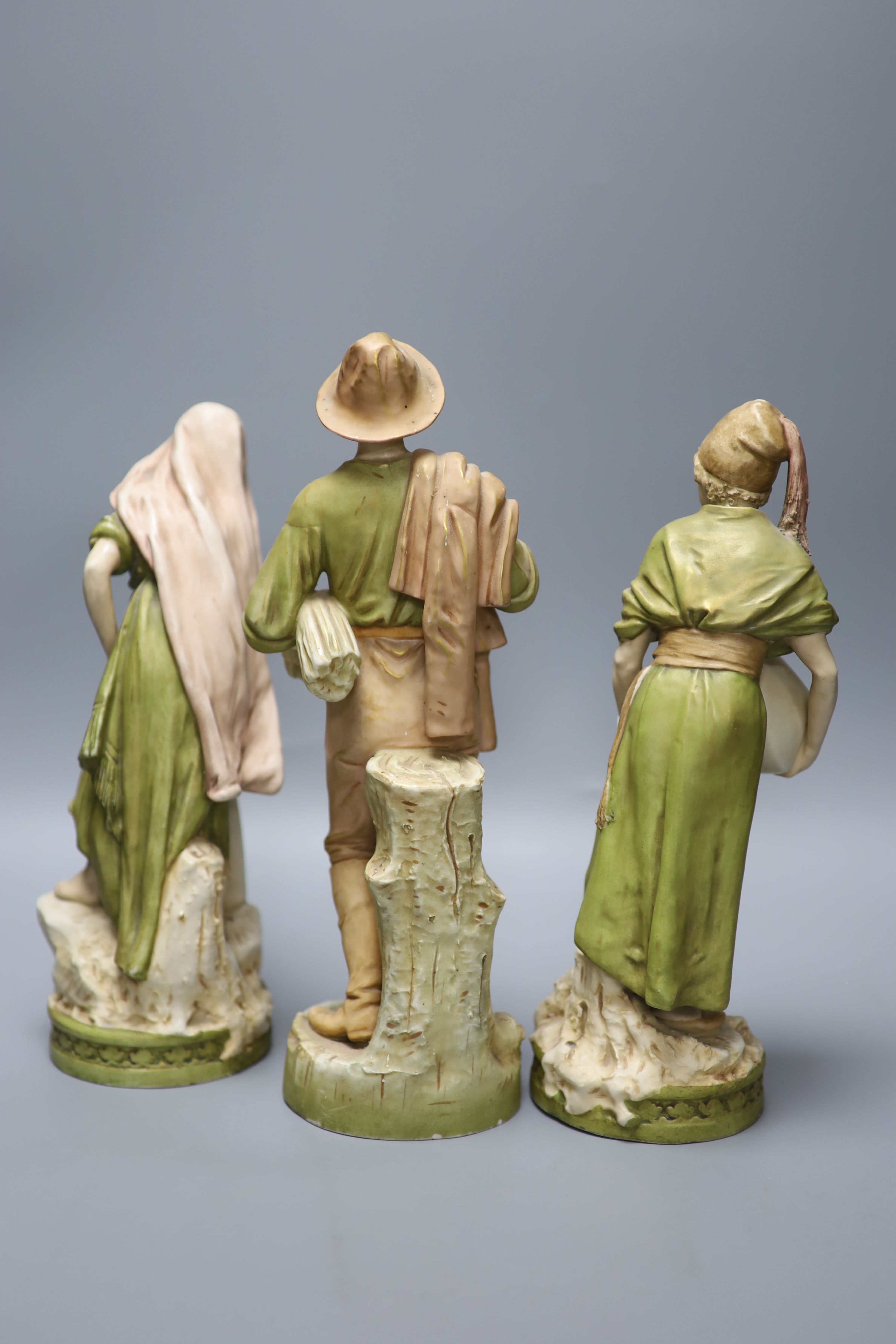 A pair of Royal Dux female water carriers and another of a farmer, 32cm